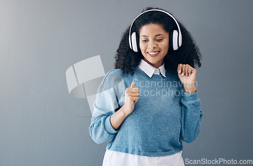 Image of Music, dance and black woman in studio with freedom, streaming or good mood on grey background. Radio, podcast and girl relax while dancing to audio, online and playlist on advertising isolated space