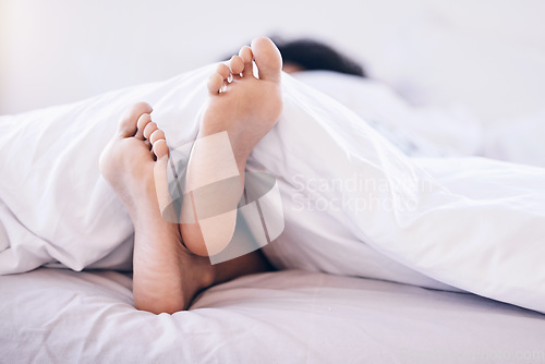 Image of Woman feet, bedroom and home of a young person in the morning feeling relax and calm. Morning, house and carefree female in a house with foot under blanket on mattress ready for sleep or nap