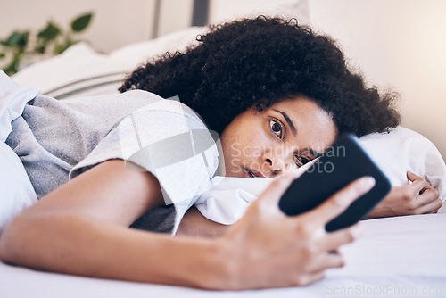 Image of Cellphone, mental health and woman in her bed with depression while watching videos on social media. Tired, sleepy and depressed female with insomnia networking on a phone in her bedroom at home.