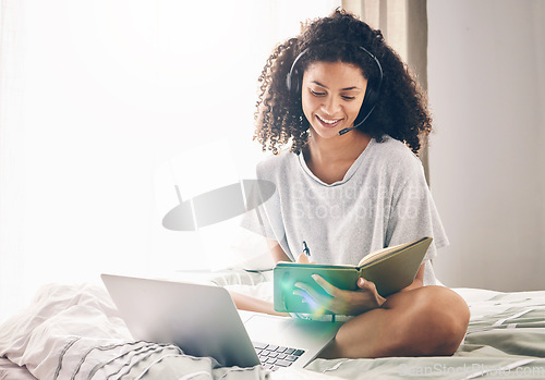 Image of Black woman, laptop and writing notes on bed in remote work for consulting, telemarketing or sales at home. Happy African American female freelancer agent with headset and computer working in bedroom