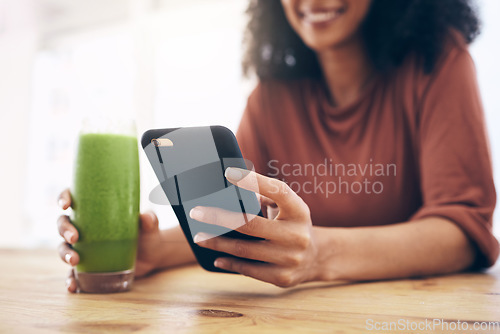 Image of Green smoothie, smartphone and woman detox, healthy breakfast or diet inspiration on internet, blog or social media. Young person hand holding phone and juice, vegan or fruit drink for nutrition