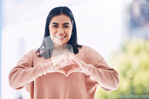 Image of Heart hands, portrait and happy woman for self care, cardiology wellness and gen z support for women health. Face of a young Indian person with love emoji, sign or gesture for like, vote and smile