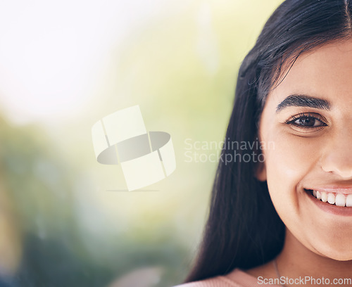 Image of Portrait, face and mockup with an indian woman outdoor standing on a bokeh green background closeup. Half, happy and smile with an attractive young female posing on blank mock up space for branding