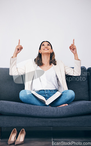 Image of Reading, book and woman on sofa pointing for mockup, empty and blank copy space in living room. Advertising, marketing and girl on couch with story, literature and textbook for knowledge or research