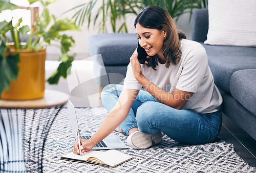 Image of Woman, phone call and laptop writing notes in the living room by sofa in remote work or studying at home. Female freelancer in conversation or discussion on smartphone, computer and notebook on floor