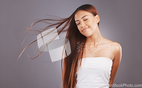 Image of Salon, hair and hairstyle by woman with care, glow and healthy skincare isolated in a studio gray background. Young, skin and natural beauty model smile due to keratin treatment for haircare