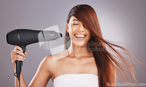 Image of Beauty, hairdryer and woman salon smile, happy and excited isolated against studio gray background. Hairstyle, model and natural hair female with self care, haircare and drying or styling