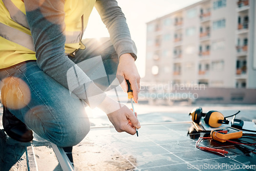 Image of Hands, solar energy and construction with a man in the city on a rooftop to install a panel for renewable power. Building, grid and electricity with a male handyman or contractor doing maintenance