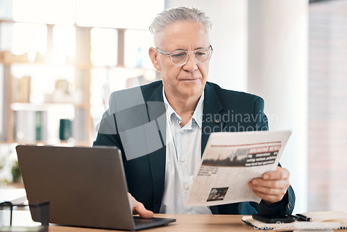 Image of Business, senior man or manager with newspaper, laptop or focus for information, modern office or planning. Corporate, male leader or entrepreneur with document, reading or concentration in workplace