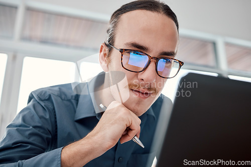 Image of Serious man, internet and laptop in office for email, typing and creative, design and idea in business. Website, search and seo guy with glasses busy on online project, task and problem solving in IT