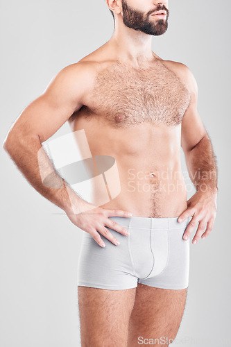 Image of Body, underwear and model with a man in studio on a gray background for health, fitness or wellness. Exercise, stomach and underpants with a male posing in studio to promote a healthy lifestyle