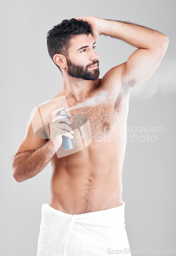 Image of Man, armpit and spray deodorant in studio for hygiene, fresh scent or perfume. Male model spraying underarm for body odor, smell and cleaning cosmetics, shower product and skincare mist on background