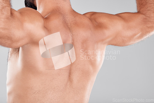 Image of Man, fitness muscle and back flexing in studio isolated on a gray background. Sports, training and male model or bodybuilder showing strong biceps after exercise, workout or bodybuilding for power.