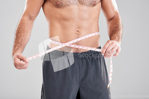 Image of Fitness, weightloss and man with measuring tape on waist, healthy diet and exercise in body care. Sports, nutrition and stomach, tracking weight loss and six pack progress isolated on grey background