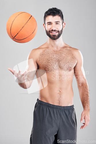 Image of Fitness, portrait of man throwing basketball in air and smile, topless and isolated on grey background. Exercise, motivation and ball sports coach or personal trainer with workout mindset in studio.