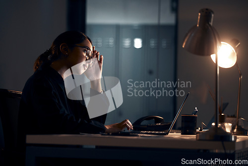 Image of Stress, laptop and business woman at night working on project, planning report and strategy deadline. Burnout, dark office and tired female worker at desk with headache, fatigue and thinking of ideas