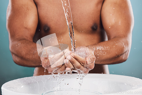Image of Closeup, basin and man washing hands, water splash and hygiene on blue studio background. Zoom, male and gentleman in bathroom, cleaning and morning routine for grooming, skincare and smooth skin