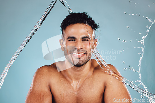 Image of Water splash, portrait and skincare man isolated on blue background face cleaning, body shower and beauty. Fitness model or person in studio headshot for aesthetic, washing and dermatology hygiene