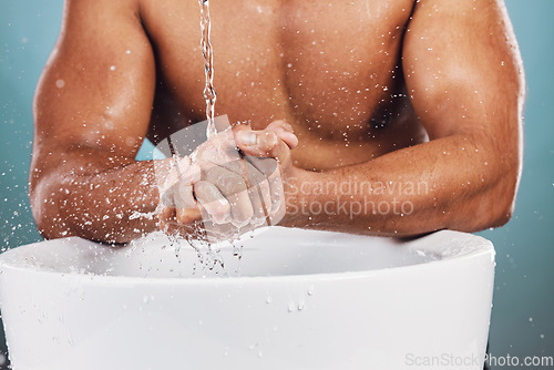 Image of Man, water splash and hands by basin for skincare, hygiene or wash against studio background. Hand of young male model in beauty, wellness and washing or cleansing for body care and self love by sink