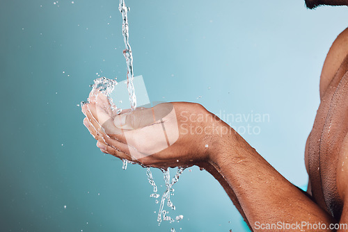 Image of Man, water splash and hands in shower for skincare hygiene, wash or hydration against a studio background. Hand of young male model in beauty, wellness and washing or cleansing for sustainability