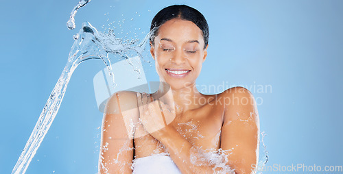 Image of Happy beauty model, water splash or showering in skincare grooming, healthcare or sustainability cleaning on isolated blue background. Zoom, smile or black woman in wet drops or hydration dermatology