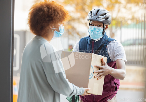 Image of Black man, mask and delivery with box for woman at house for logistics, cargo and safety from covid 19. Young african courier, package and shipping service with stock, helmet and e commerce in city