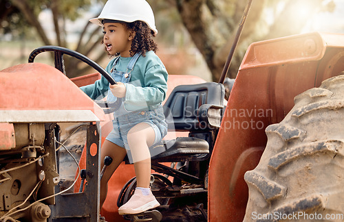 Image of Girl kid in tractor, agriculture and farming transport, sustainability and learning field work with development and fun. Childhood, farm machinery and farmer in training with growth and young child