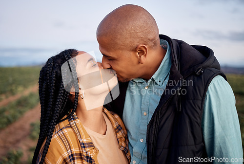 Image of Agriculture, sustainability and a couple kissing on a farm outdoor for growth in nature during the harvest season. Love, summer or farming with a man and woman sharing a kiss in the countryside