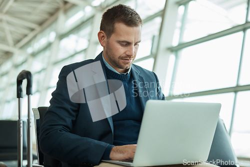 Image of Business man, airport and laptop for travel while working in lobby to check flight booking. Entrepreneur person with luggage in building while typing or writing email or report on trading investment