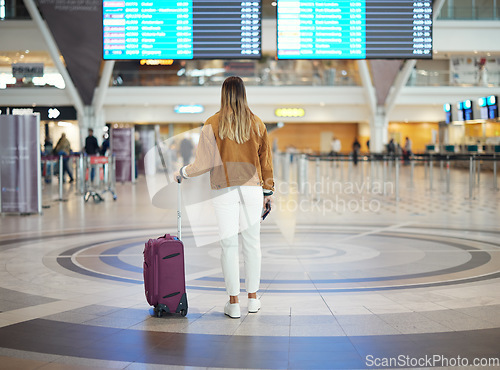 Image of Woman, airport and luggage checking flight times for travel, vacation or journey with passport in Cape Town. Female traveler standing and waiting ready for departure, boarding plane or immigration