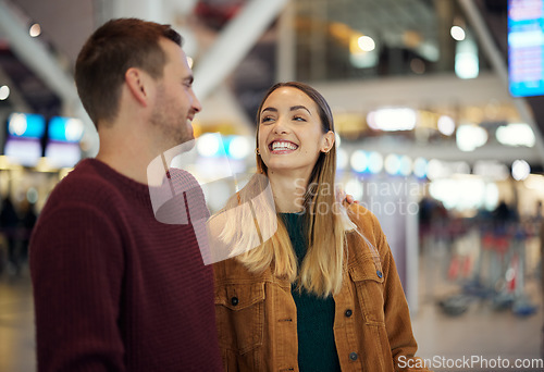 Image of Love, travel and couple at airport talking, chatting or laughing at funny joke. Valentines day, comic and happy man and woman in airline lobby waiting for flight departure for vacation or holiday.