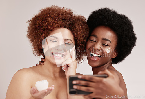 Image of Skincare, smile and beauty with friends and selfie for product, facial and spa. Cosmetic, phone and social media with cream on face of black women for health, makeup or wellness in studio background