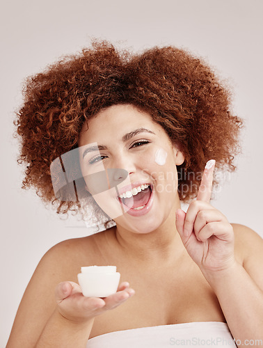 Image of Skincare, portrait of black woman and cream on finger, smile and afro, advertising luxury product. Dermatology, cosmetic and facial beauty for happy model isolated on studio background, lotion in jar
