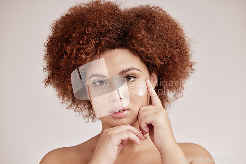 Image of Skincare, portrait of black woman with cream on serious face, afro and advertising luxury product promotion. Dermatology, cosmetics application and facial beauty, model isolated on studio background.