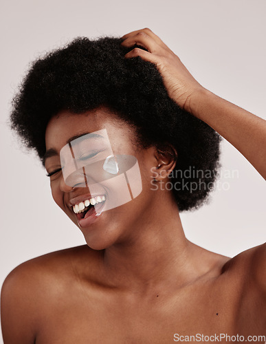 Image of Skincare, cream on face and black woman with hand on hair, smile and afro, advertising luxury skin product promotion. Dermatology, cosmetics and facial for happy model isolated on studio background.