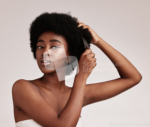 Image of Afro hair comb, black woman and face of a model with care, salon and cosmetics. Hairdresser, African hairstyle and beauty of a young person doing a treatment for self care in a isolated studio