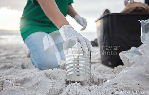 Image of Recycle, volunteer hand cleaning beach and can in sand, picking up dirt at ocean on earth day. Community service, sustainability and environmental charity, people pick up trash for future of planet.