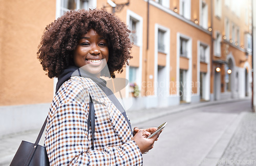 Image of Portrait, phone and mockup with a black woman in the city for travel, tourism or adventure overseas. Smile, mobile and mock up with a female traveler outside in a foreign town in Germany