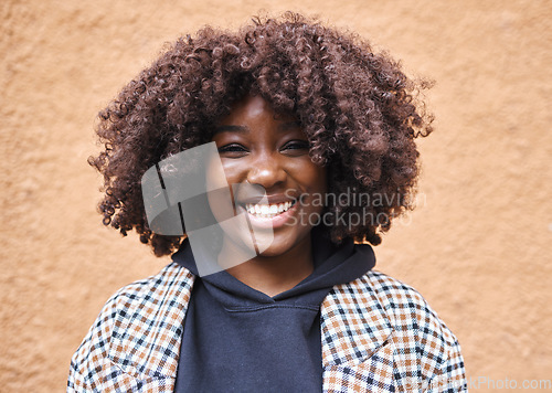 Image of Black woman, portrait and afro on wall background in city, urban town or fun in Kenya. Happy young african female smile for happiness, face and curly hair outdoors with fashion, motivation or freedom