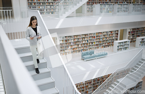 Image of Walking student, tablet or woman in library for social media, education or learning. Bookshelf, books or girl on tech for scholarship networking, search or planning school project at collage campus