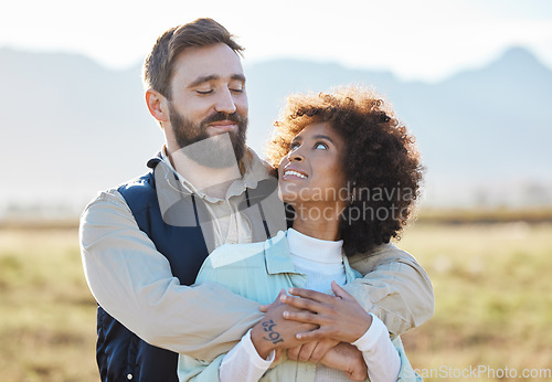 Image of Love, happy and hug with interracial couple on farm for agriculture, peace and growth. Teamwork, countryside and nature with man and black woman in grass field for sustainability, agro or environment