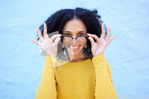 Image of Spectacle glasses, portrait and black woman on blue background, optical face and trendy cool clothes. Eyewear, smile and happy girl model with vision lenses, yellow color fashion or urban wall mockup