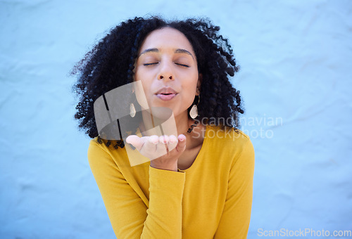 Image of Black woman blowing kiss in air for love, care and flirting on blue background, wall backdrop or outdoor. Young girl, hand kisses and expression of happiness, romance and kissing face emoji with lips