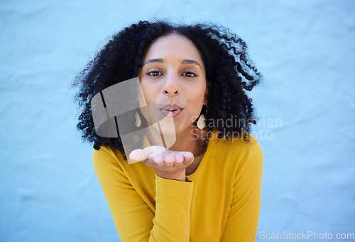 Image of Black woman, portrait and blowing kiss for love, care and flirting on blue background, wall backdrop or outdoor. Young girl, hand kisses and expression of happiness, romance and kissing face emoji