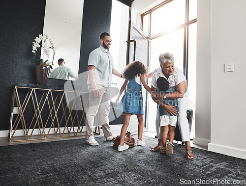 Image of Family, grandmother and children hug as greeting in a home or house due to grandparent visit on holiday or vacation. Kids, grandchildren and elderly woman embrace feeling excited, happy and happiness