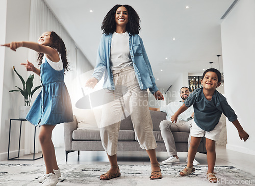 Image of Happy family, fun and dance in a living room by mother and children playing, bonding and happy in their home. Kids, parents and dancing game in a lounge on a weekend, cheerful and happiness together