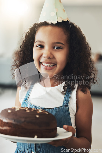 Image of Portrait of happy girl with birthday cake, child in home and surprise celebration in Atlanta house alone. Young kid with smile in homemade chocolate dessert, hat on curly hair and excited african