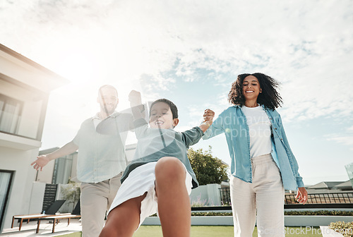 Image of Children, family and a boy swinging with his parents outdoor in the garden of their home together. Kids, love or playing with a mother, father and son having fun while bonding in the backyard