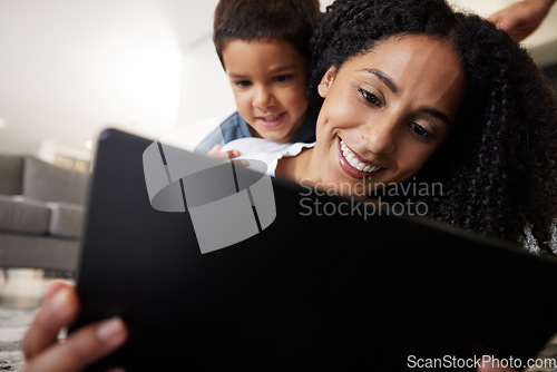 Image of Love, mother with son on back and on floor with tablet, reading and learning together for quality time. Happy, mama and boy on ground, device and bonding on break, weekend and enjoy online videos