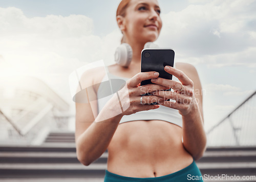 Image of City, fitness and woman with smartphone, communication and smile typing after exercise low angle. Health, workout and personal trainer on phone, conversation and connect or network in sports training